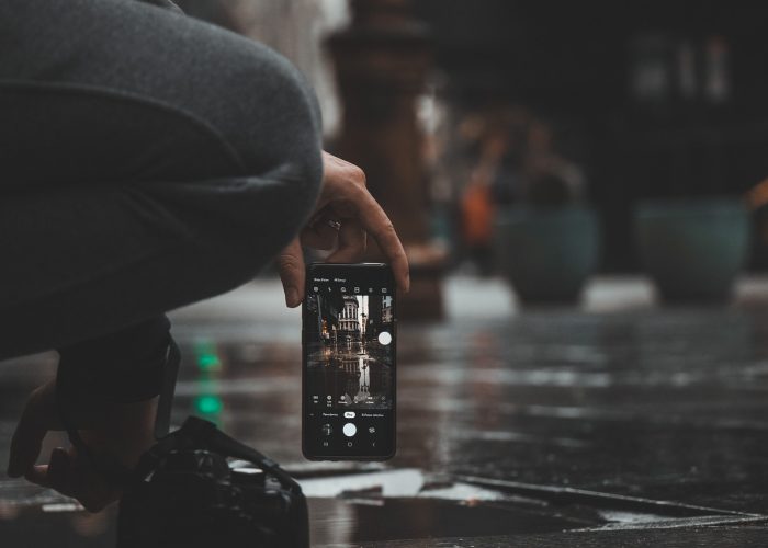 手机屏幕显示体育App注册页面与验证码输入框，手指正在点击确认按钮完成账号注册流程